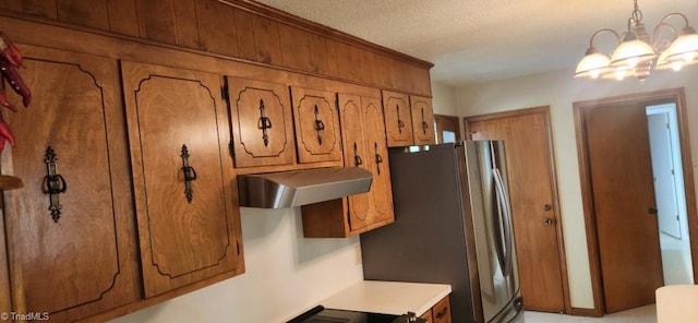 kitchen featuring stainless steel fridge, a textured ceiling, a chandelier, and decorative light fixtures