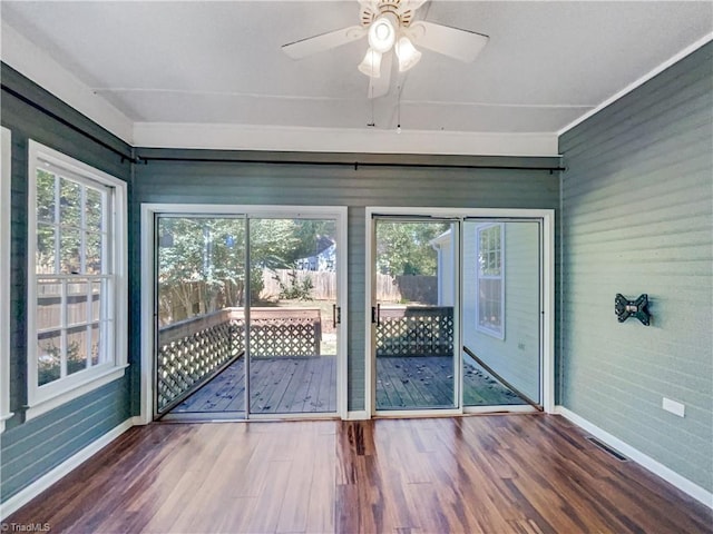 unfurnished sunroom featuring ceiling fan