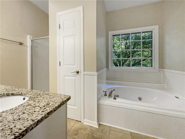 bathroom featuring tile patterned flooring, plus walk in shower, and vanity