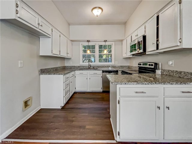 kitchen featuring stainless steel appliances, dark hardwood / wood-style flooring, dark stone counters, and white cabinetry