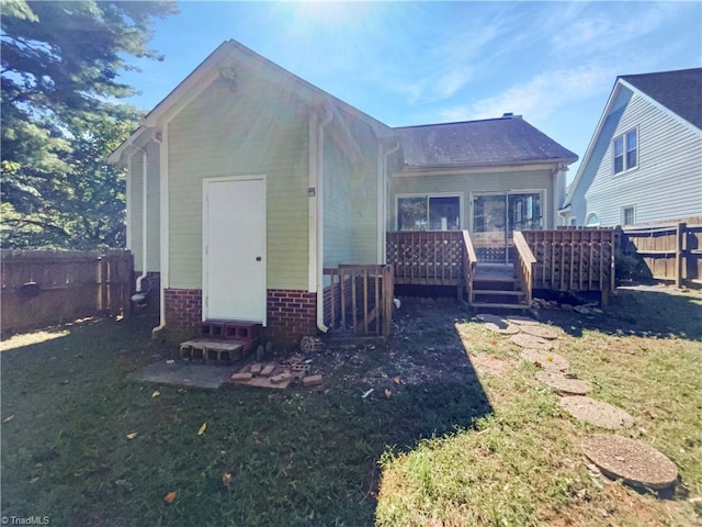 back of house with a yard and a wooden deck