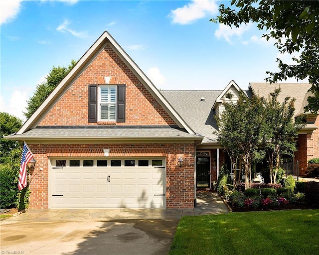 129 Turnbuckle Ct, Clemmons, NC 27012 - traditional-style home with driveway, roof with shingles, brick siding, a front yard, and an attached garage