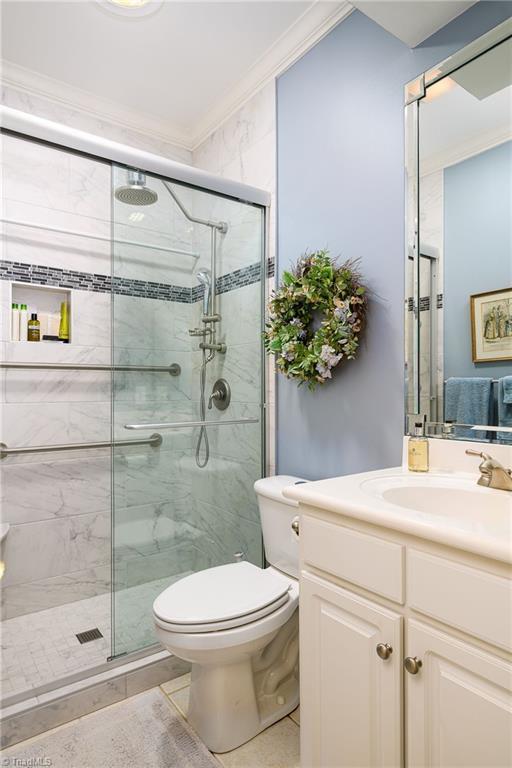 129 Turnbuckle Ct, Clemmons, NC 27012 - full bathroom with crown molding, vanity, and a shower stall