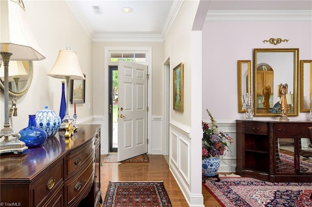 129 Turnbuckle Ct, Clemmons, NC 27012 - entryway featuring arched walkways, a wainscoted wall, ornamental molding, wood finished floors, and a decorative wall