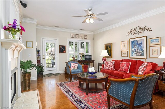 129 Turnbuckle Ct, Clemmons, NC 27012 - living area with a ceiling fan, wood finished floors, a fireplace with flush hearth, and ornamental molding