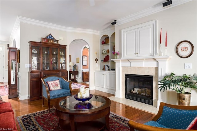 129 Turnbuckle Ct, Clemmons, NC 27012 - living room featuring wood finished floors, built in features, crown molding, a fireplace, and arched walkways