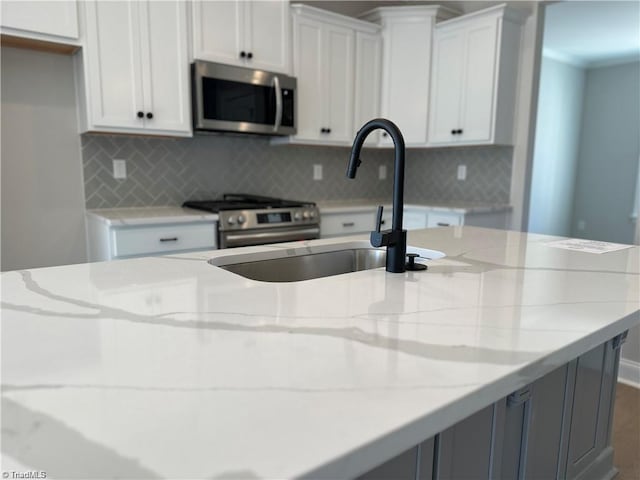 308 Grandworth Way, King, NC 27021 - kitchen featuring appliances with stainless steel finishes, light stone countertops, backsplash, and white cabinetry