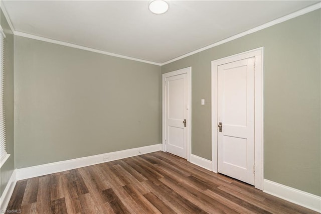 spare room with ornamental molding and dark wood-type flooring