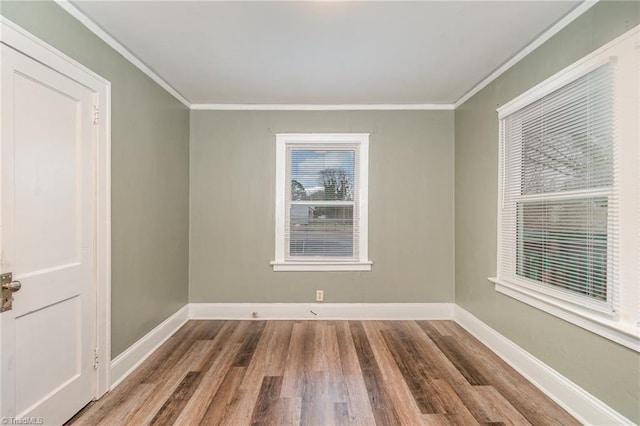 spare room with hardwood / wood-style flooring and crown molding