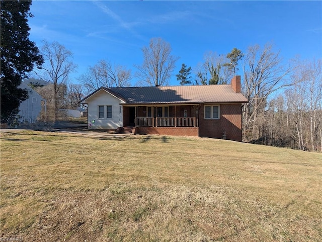 view of front of home with a chimney, a porch, and a front yard