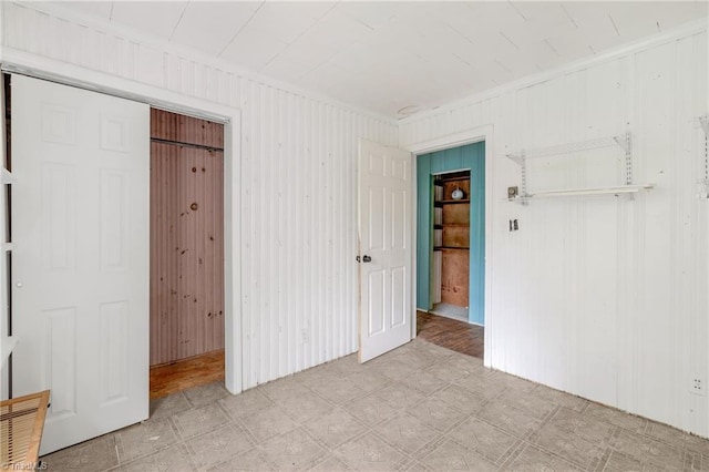 1198 Red Bank Rd, Germanton, NC 27019 - unfurnished bedroom with tile patterned floors, a closet, ornamental molding, and wooden walls