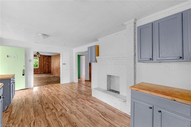 1198 Red Bank Rd, Germanton, NC 27019 - unfurnished living room with light wood-style floors, a brick fireplace, ceiling fan, and crown molding