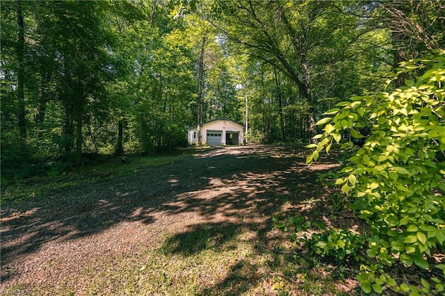 5750 Gayray St, Clemmons, NC 27012 - view of yard featuring a detached garage, an outbuilding, and a wooded view