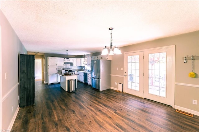 5750 Gayray St, Clemmons, NC 27012 - kitchen featuring appliances with stainless steel finishes, dark wood-style flooring, white cabinetry, a chandelier, and a textured ceiling