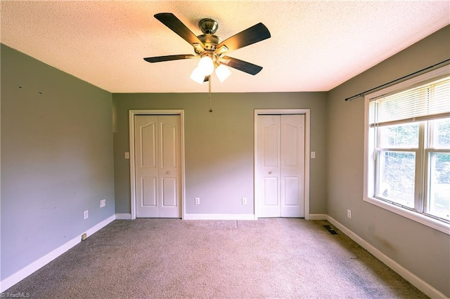 5750 Gayray St, Clemmons, NC 27012 - unfurnished bedroom with two closets, carpet flooring, a textured ceiling, and a ceiling fan