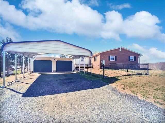 exterior space featuring a carport, fence, brick siding, and driveway