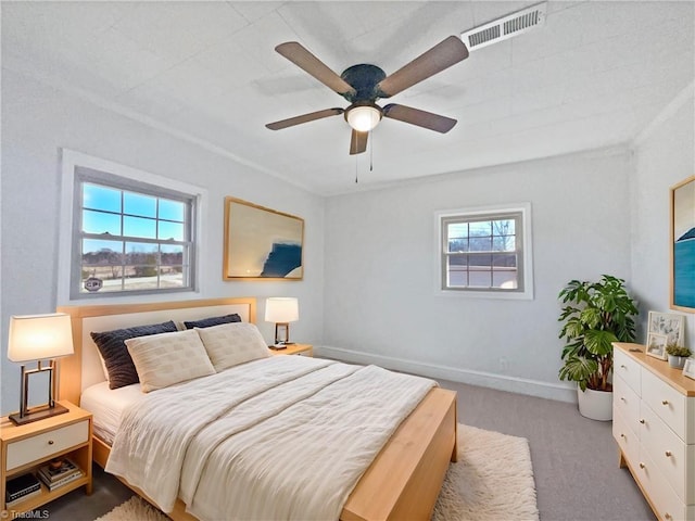 bedroom featuring a ceiling fan, baseboards, visible vents, and light carpet