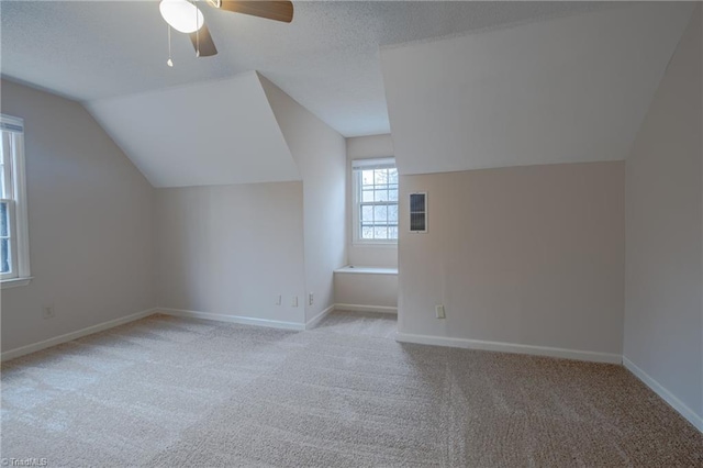 bonus room featuring lofted ceiling, light colored carpet, and ceiling fan