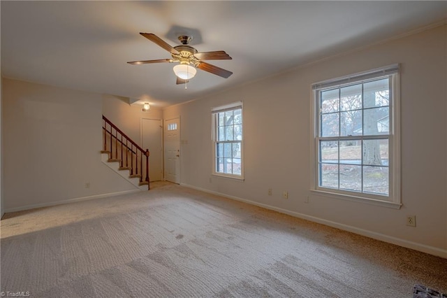 unfurnished living room with ornamental molding, light colored carpet, and ceiling fan