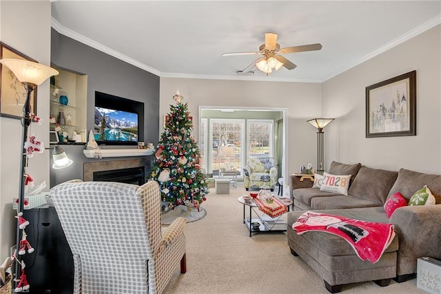 living room with light carpet, a fireplace, ornamental molding, and ceiling fan