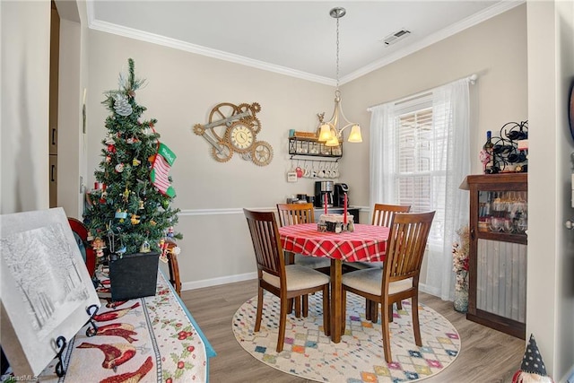 dining room featuring hardwood / wood-style floors, a notable chandelier, and ornamental molding