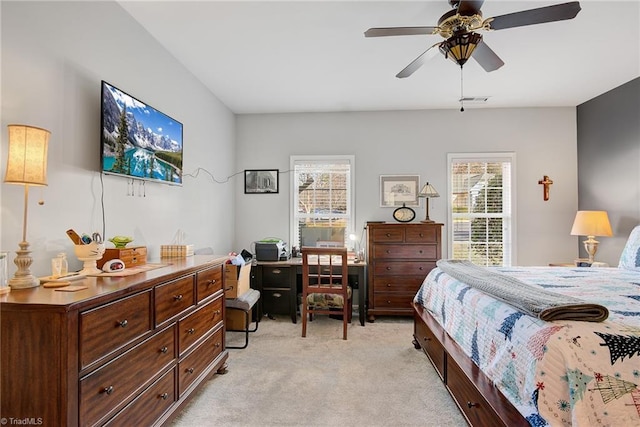 bedroom featuring ceiling fan, light carpet, and multiple windows