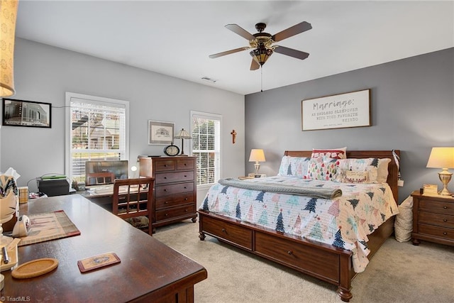 carpeted bedroom featuring multiple windows and ceiling fan