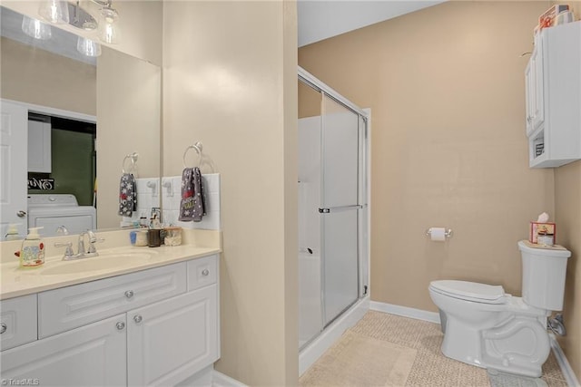 bathroom with walk in shower, tile patterned flooring, vanity, and washer / dryer