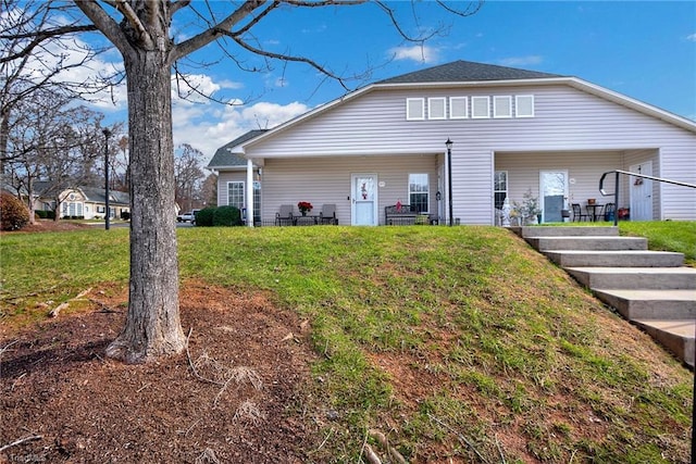 rear view of property featuring a yard