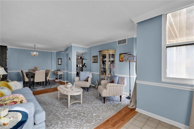 living room with light hardwood / wood-style floors, a chandelier, and crown molding