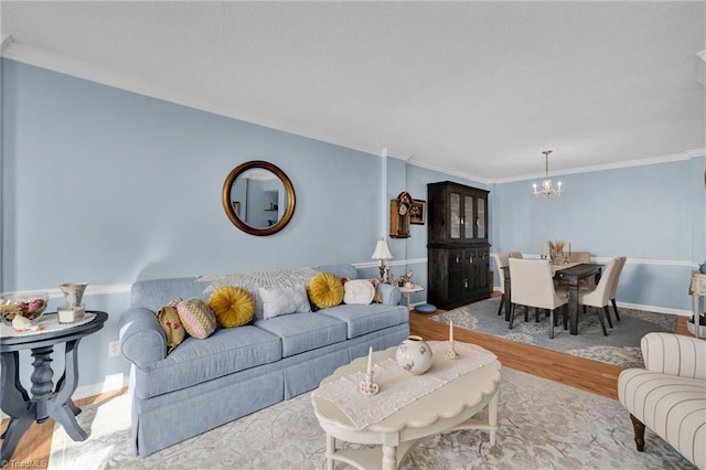 living room featuring an inviting chandelier, crown molding, and light hardwood / wood-style flooring