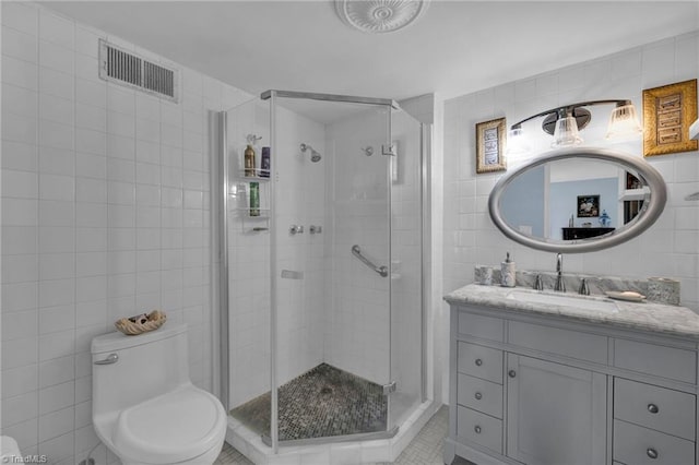 bathroom featuring tile walls, tile patterned floors, walk in shower, vanity, and toilet