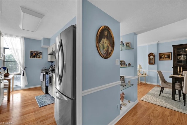 kitchen featuring stainless steel appliances, white cabinets, and light wood-type flooring