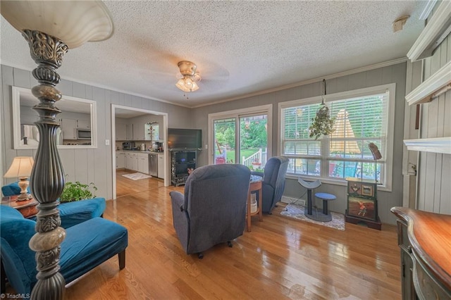2205 Sedgemont Dr, Winston-Salem, NC 27103 - living room featuring crown molding, a textured ceiling, light wood-style flooring, and ceiling fan