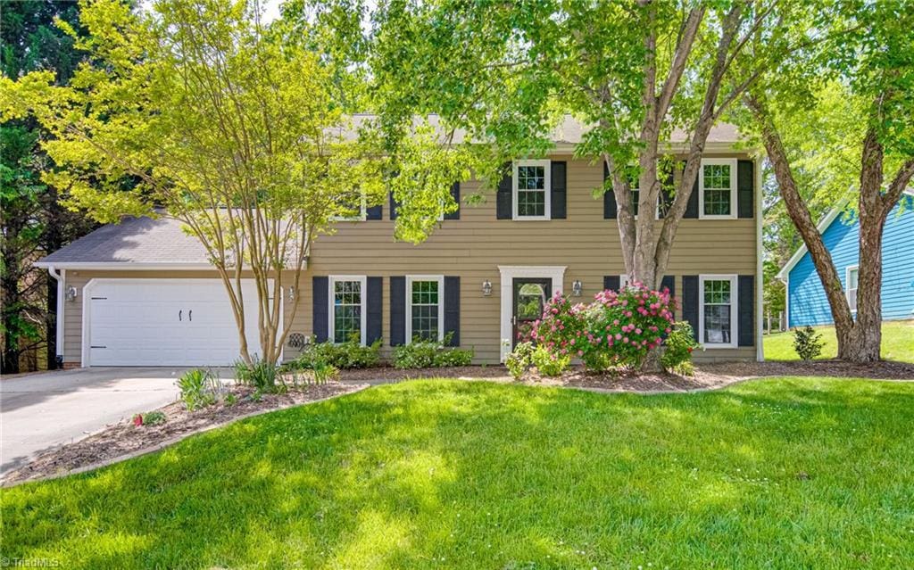 1910 Kildare Woods Dr, Greensboro, NC 27407 - colonial-style house featuring a garage, concrete driveway, and a front yard