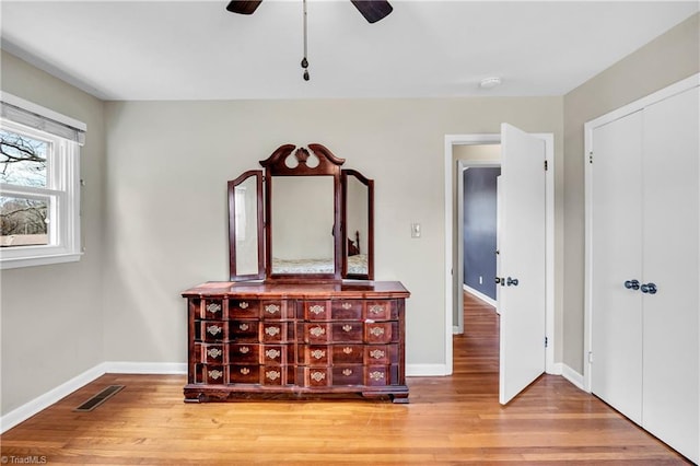 bedroom featuring visible vents, baseboards, a closet, and wood finished floors