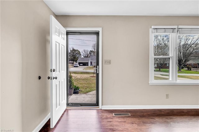 foyer entrance featuring wood finished floors, visible vents, and baseboards