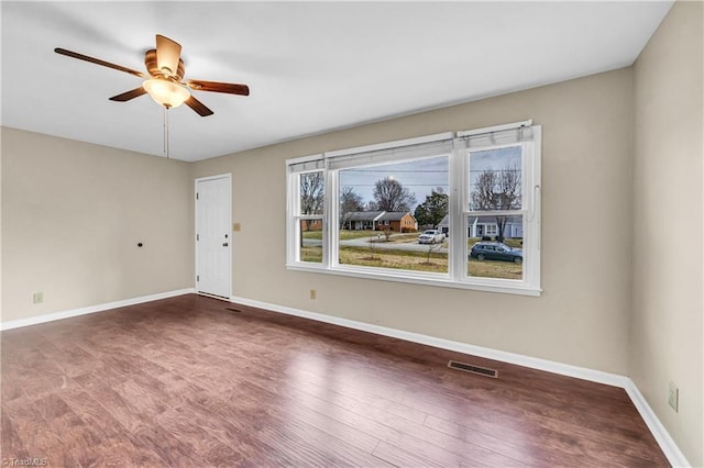 unfurnished room featuring visible vents, ceiling fan, baseboards, and wood finished floors