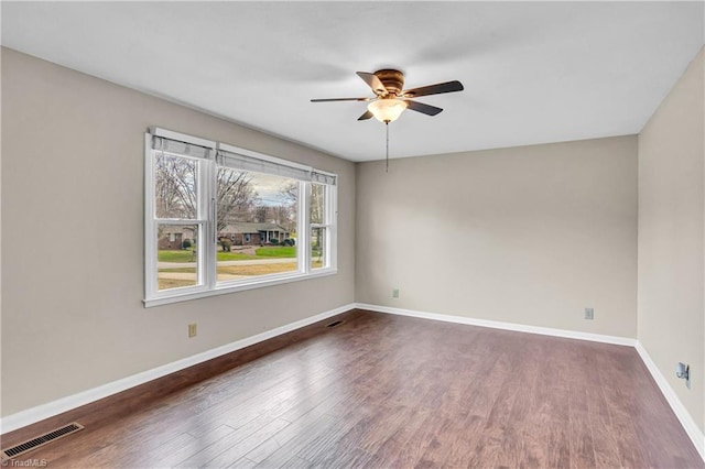 unfurnished room with visible vents, a ceiling fan, baseboards, and wood finished floors