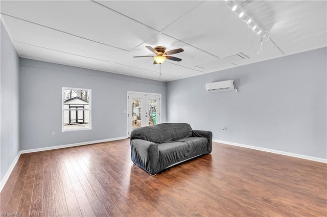 sitting room featuring french doors, baseboards, wood finished floors, and a wall mounted AC