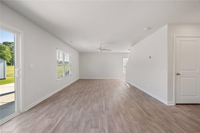 spare room featuring light wood finished floors, baseboards, and ceiling fan