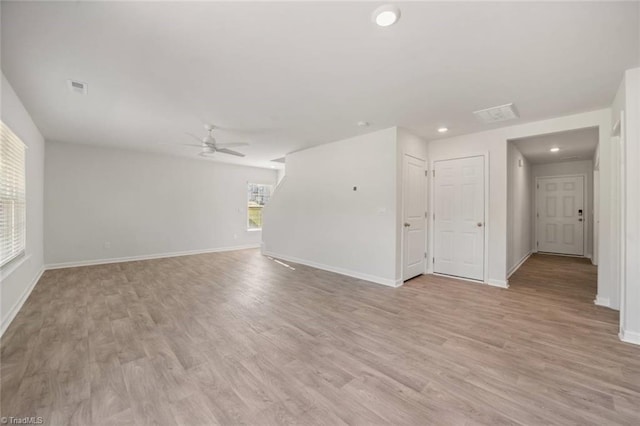 unfurnished living room featuring a ceiling fan, baseboards, and light wood-type flooring