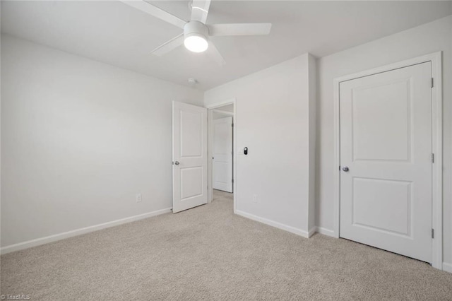 unfurnished bedroom featuring baseboards, carpet flooring, and a ceiling fan