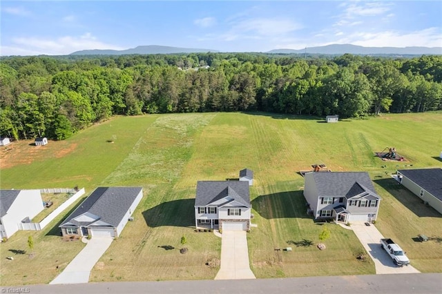 birds eye view of property with a mountain view and a wooded view