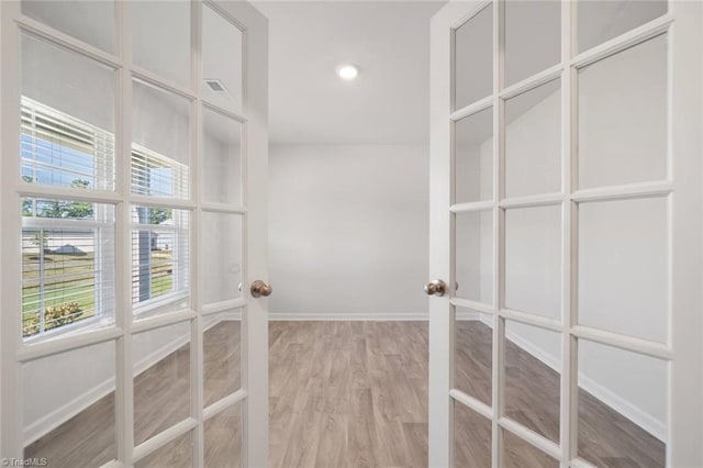spacious closet with light wood-style floors and french doors