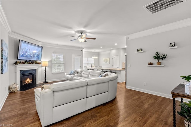 living room featuring dark hardwood / wood-style flooring, ceiling fan, and crown molding