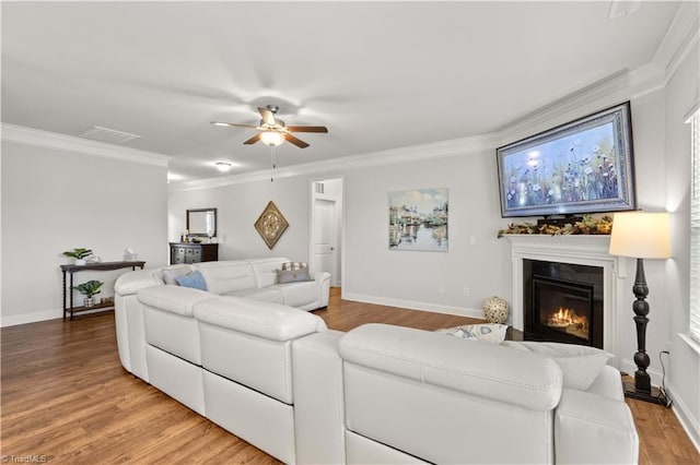 living room featuring crown molding, ceiling fan, and wood-type flooring