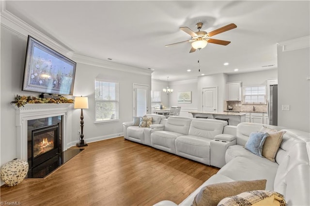 living room featuring ceiling fan, light hardwood / wood-style floors, and ornamental molding