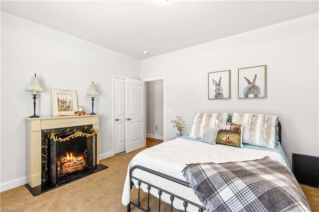 bedroom with carpet and a fireplace