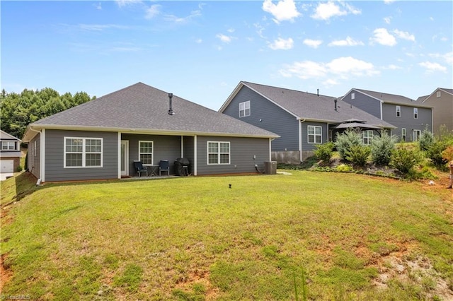 rear view of house with a lawn and central AC